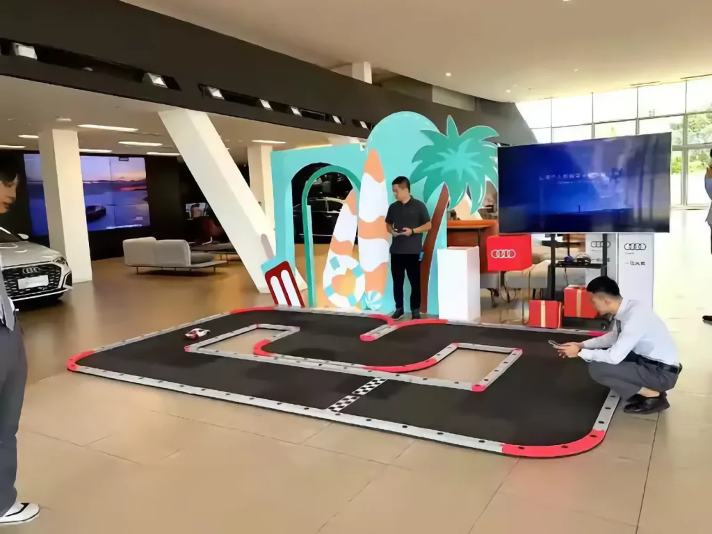 Participantes junto a una pista modular de radiocontrol instalada en un concesionario