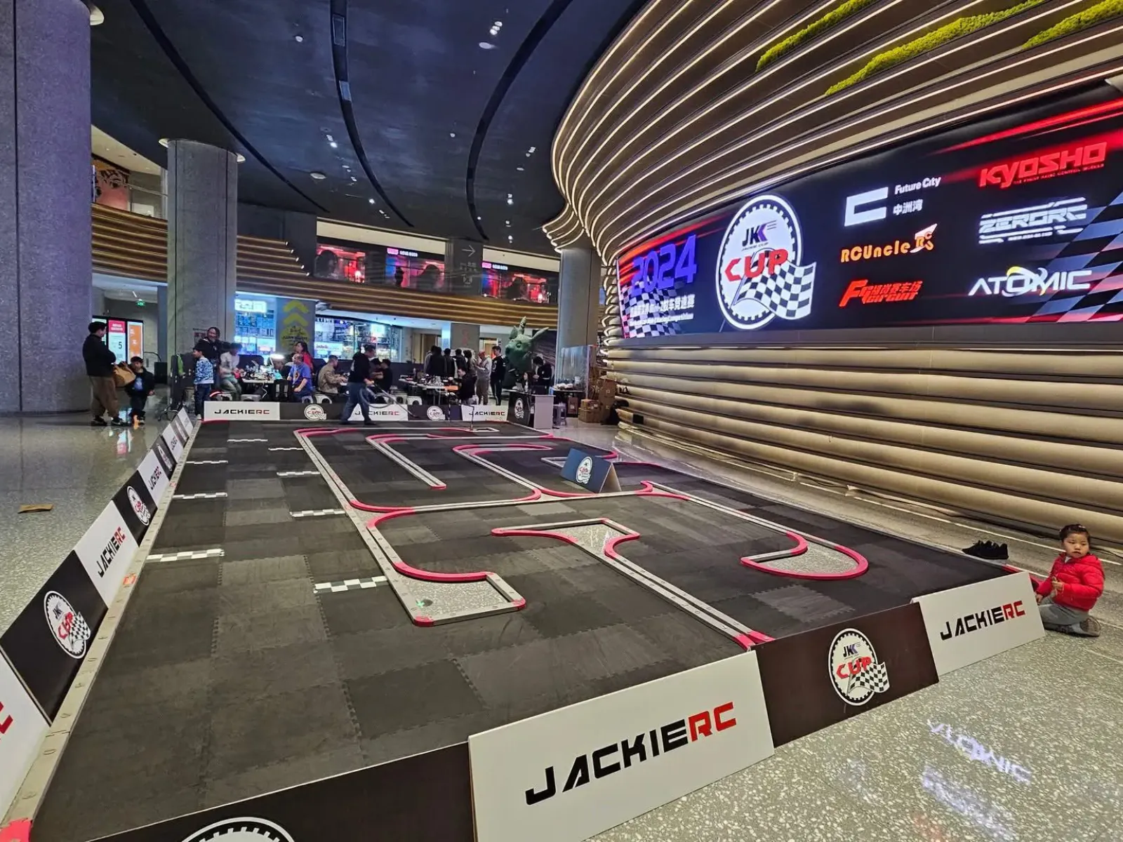 Circuito modular de radiocontrol con curvas y barreras en un recinto comercial