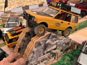 Todoterrenos de Radio Control Traxxas en un circuito crawler 4x4 superando un obstáculo con acabado de roca